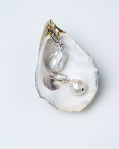 A pair of baroque pearl earrings with silver-tone latch-back clasps and a twisted knot detail.