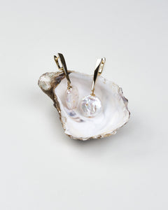 A pair of long white baroque pearl earrings with gold-colored clasps, displayed on a white background.