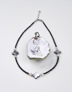 Mayfair Pearls necklace with black beads, pearls, and mother-of-pearl clover motifs.