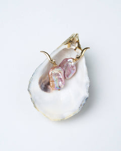 A pair of blush-toned baroque pearl earrings with square-shaped pearls in peach and lavender hues, on a gold-tone hook with cubic zirconia accents.