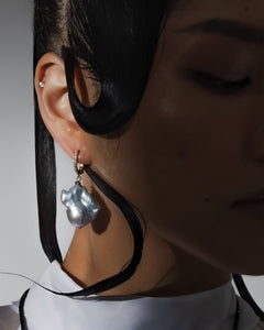 Editorial close-up of model wearing silver baroque pearl drop earrings — Mayfair Pearls statement jewellery, gifts for her