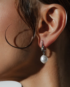 Woman wearing silver knot freshwater pearl drop earrings for an elegant minimalist look from Mayfair Pearls