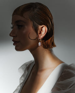 Woman wearing earrings with a neutral background